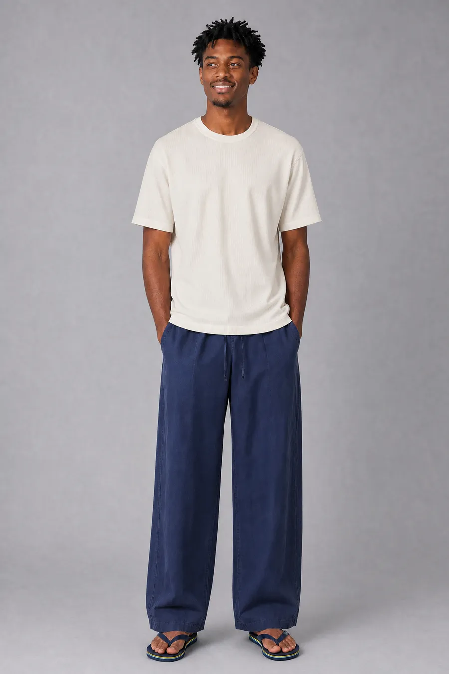 KI-generiertes On-Model-Bild: Model in cremefarbenem T-Shirt und weiter navyblauer Hose